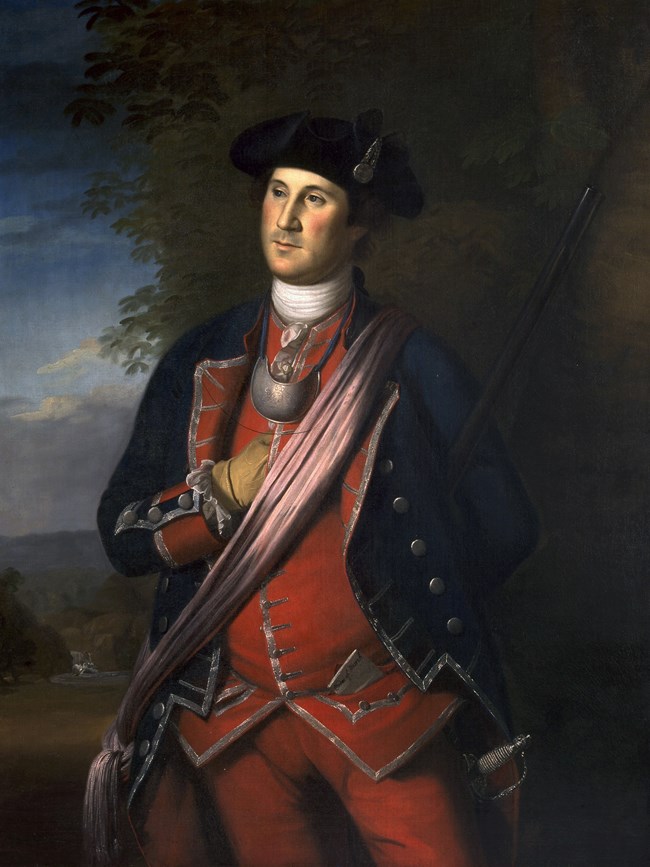 George Washington Man standing, wearing a red militia uniform with a blue coat and black tri-corner hat.
