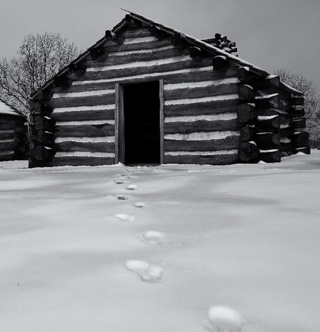 Footprints in snow lead to a log structure