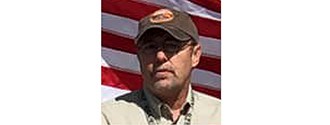 a man stands at a podium with the american flag and grand canyon behind