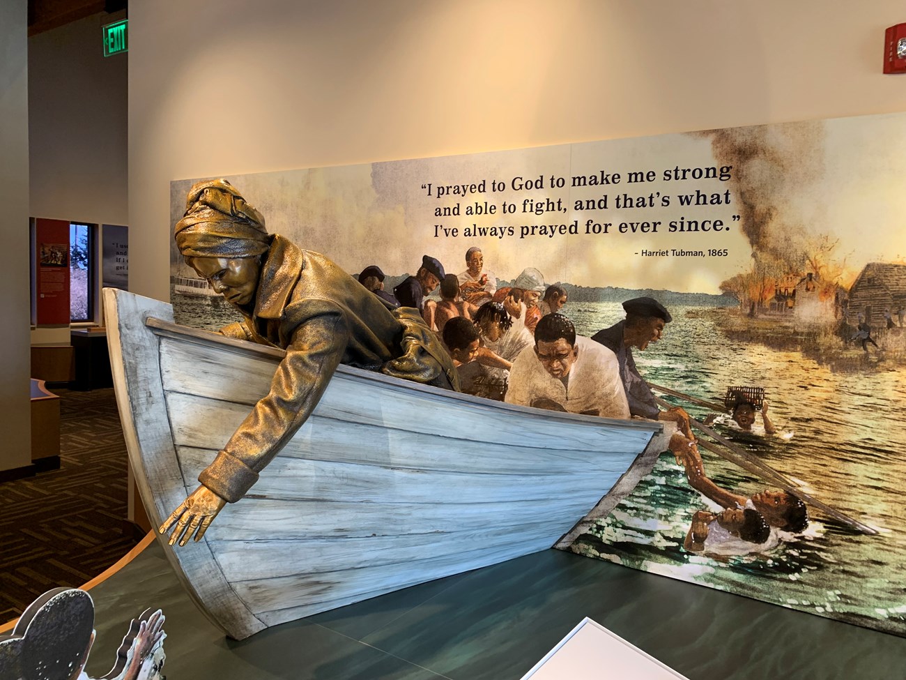 VisitorCenterTubman A museum exhibit with a sculpture of Harriet Tubman rescuing people from the water.