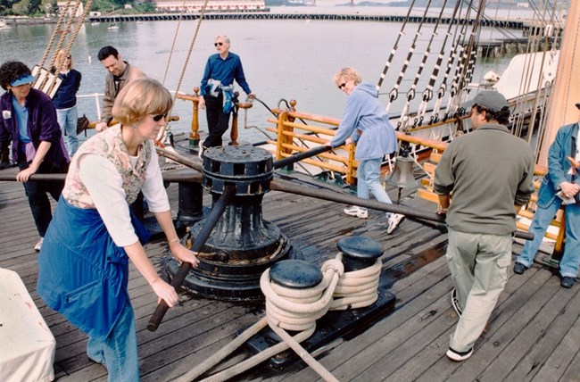 Visitors holding capstan bars, turn the capstan Visitors holding capstan bars, turn the capstan