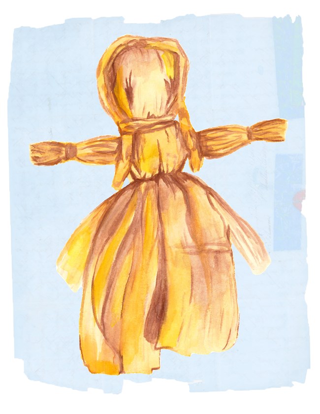 Corn husk doll painting on blue paper.