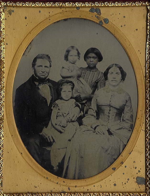 A black and white portrait of Charles and Philena Camden with daughter Ada (foreground) and daughter Grace, held by Kate Camden in between Charles and Philena.