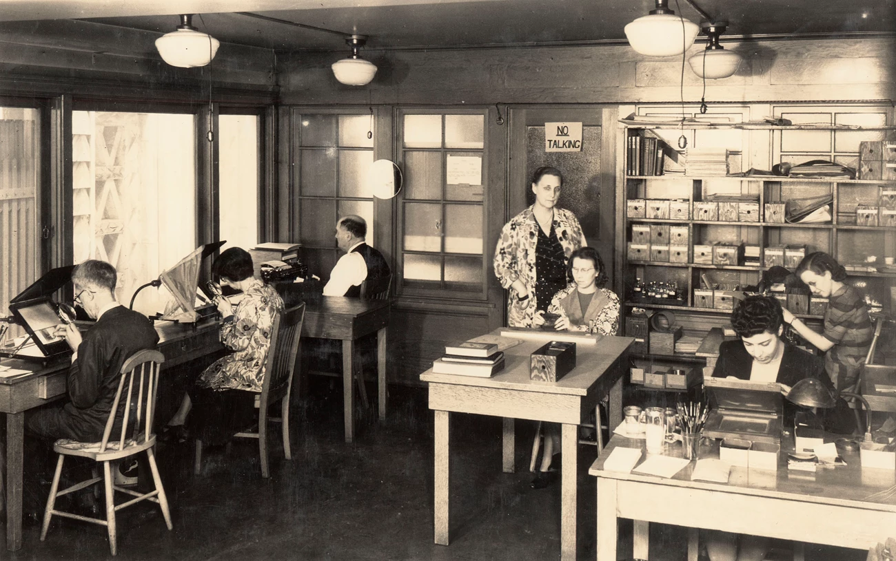 WML Lantern Slide Lab Men and women working over magnifying viewers to paint lantern slides.