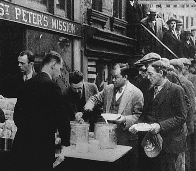 Men stand in a bread line for food