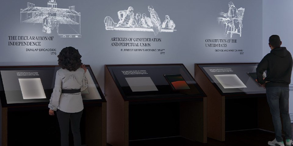 West Wing Exhibit Two people examining historic documents in artifact display cases.