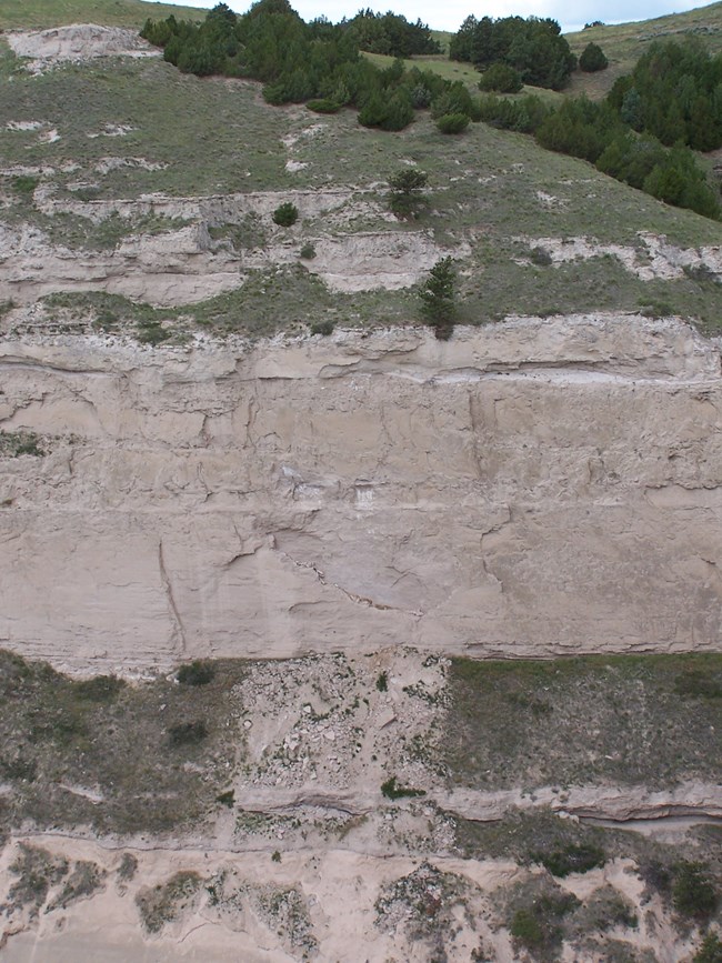 Pieces of a sandstone bluff are seen scattered at its base.