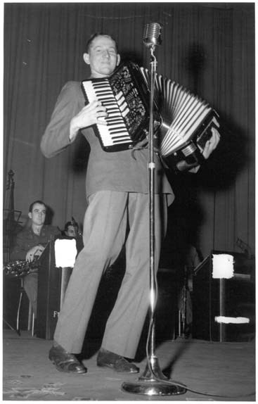 a man in a suit playing the accordion