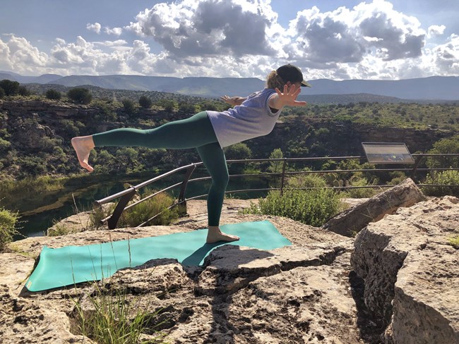 A Park Ranger demonstrates flying bird pose at the Montezuma Well overlook. A Park Ranger demonstrates flying bird pose at the Montezuma Well overlook.