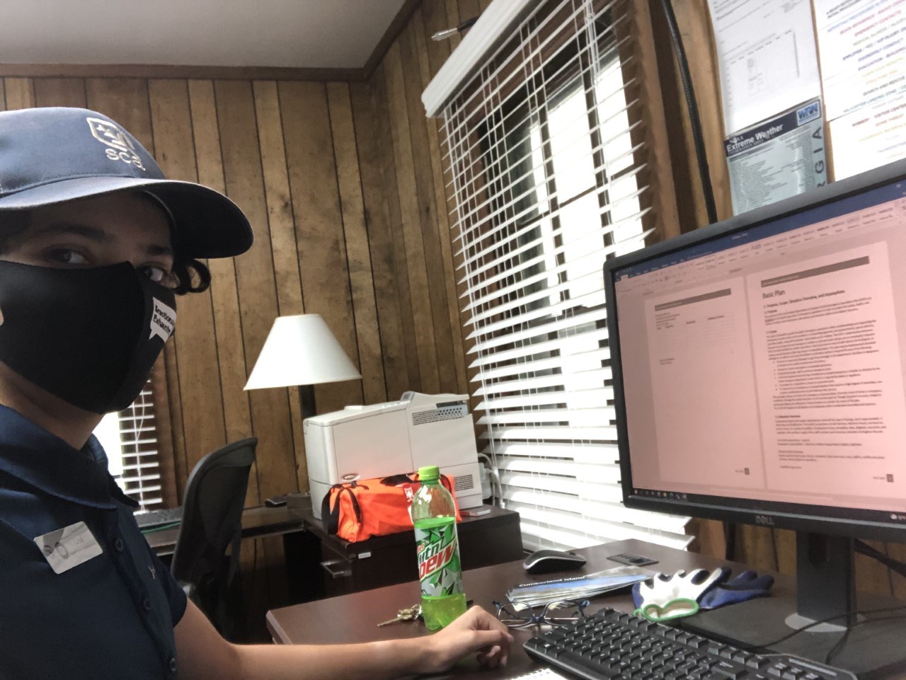 Structural Fire Protection Intern Lisa Weir A person wearing a cloth face mask sits in front of a computer screen in an office.