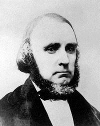 A black and white image of a man with a chinstrap beard.