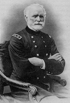 black and white photo of a bearded man sitting in a chair in military uniform