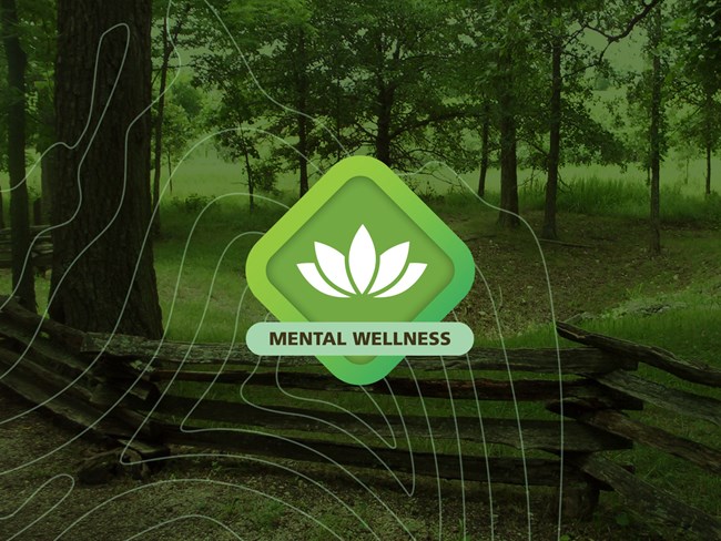 Wilson's Creek NPS Mental Wellness Hero Green grass logo with the words Mental Challenge on top centered in the middle of a field picture of the trail along Bloody Hill by the sinkhole surrounded by split rail fencing.