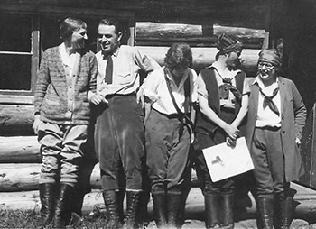 Unidentified women and a man with Marguerite Lindsley stand facing forward the group is all laughing and talking.