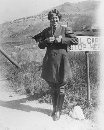 Ranger Frances Pound in uniform at Yellowstone National Park she clasps both her lapels as she smiles at the camera