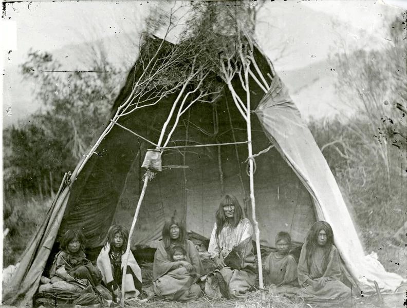 YELL 8151 Black and white photo of a group of Tukudika men women and children sitting.