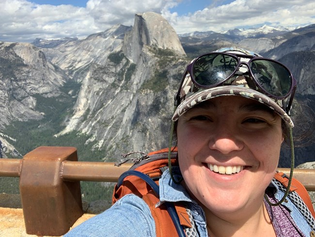 Ranger Emily Dayhoff taking a selfie over on a glacier overlook