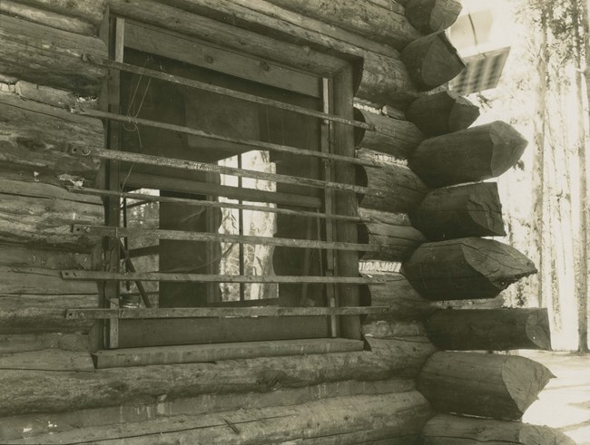 Metal bars over a window in a log cabin