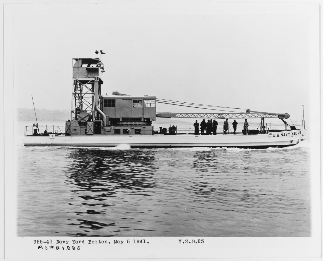 A utilitarian service craft, YSD-23, is a seaplane wrecking derrick, floating on the water.