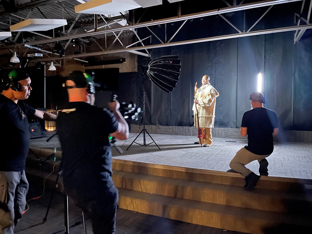 A man in historic clothes being recorded on a stage