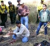 Members of Yosemite Fire look on as the Southern Sierra Miwuk engage in a ceremony and traditional methods to ignite the prescribed fire. NPS Photo by Brent Johnson. Members of Yosemite Fire look on as the Southern Sierra Miwuk engage in a ceremony and traditional methods to ignite the prescribed fire. NPS Photo by Brent Johnson.