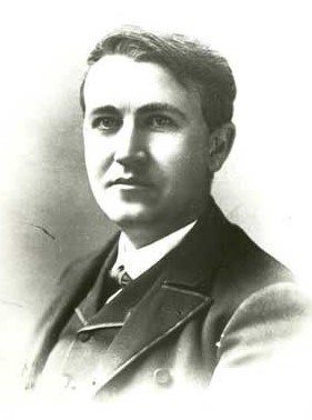 A black and white photo of a man in a suit with dark hair.