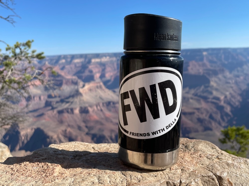 Water bottle with a sticker reading "FDW Friends with Delia" on a canyon ledge
