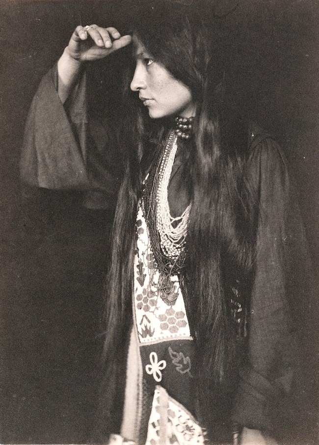 Photo of woman with her hand to her head.
