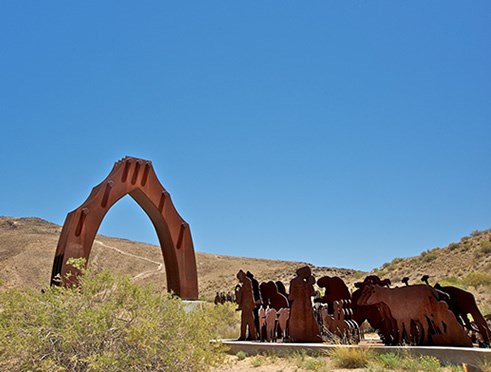 The history and adventure of El Camino Real travelers is honored in La Puerta del Sol, a sculpture by Armando Alvarez, that greets visitors to El Cerro de Tomé. Photo © Jack Parsons