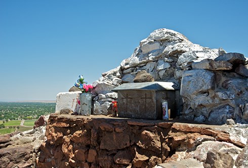 Pilgrims and hikers frequently leave objects of spiritual and personal meaning at a masonry shrine atop El Cerro de Tomé. Photo © Jack Parsons