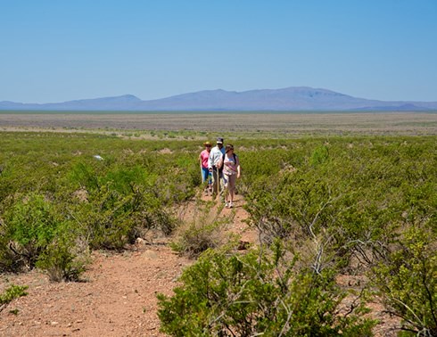 Three well-equipped hikers begin their El Camino Real adventure along the 1 1/2-mile bilingual interpretive trail through the Yost Draw section of the Jornada del Muerto. Photo © Jack Parsons