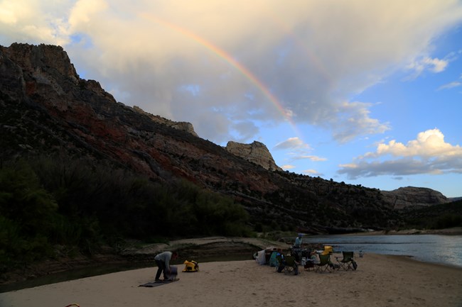 Rangers on a rafting trip make camp on the river banks.