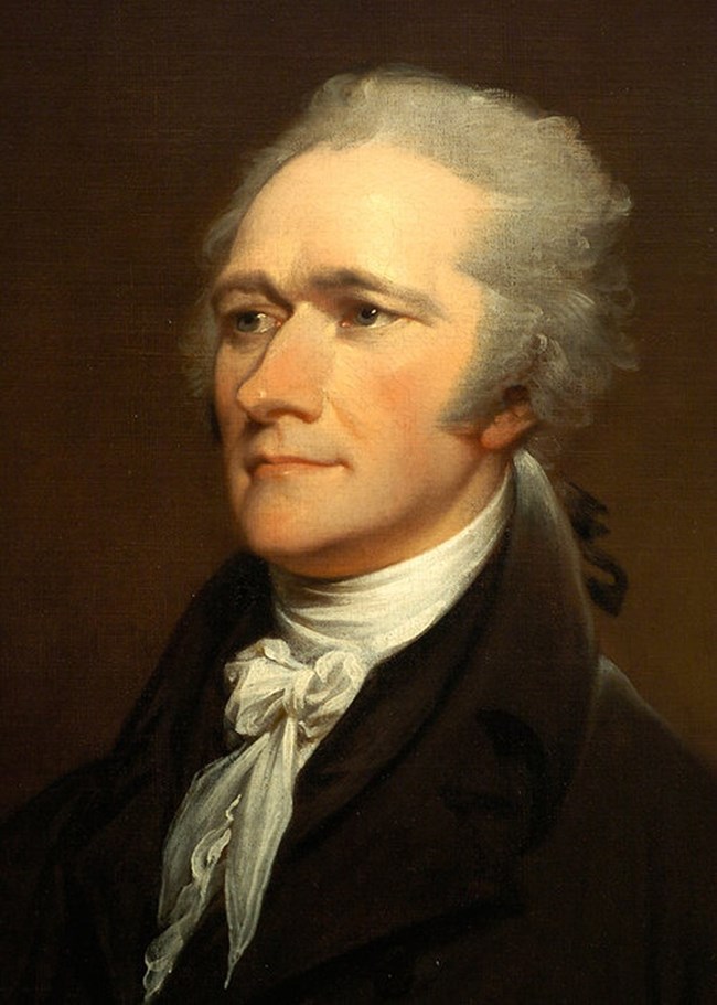 A portrait of a gray haired Hamilton wearing a dark suit