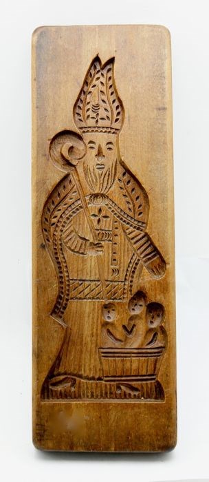A cookie mold shaped like a man with a beard and bishop's hat.