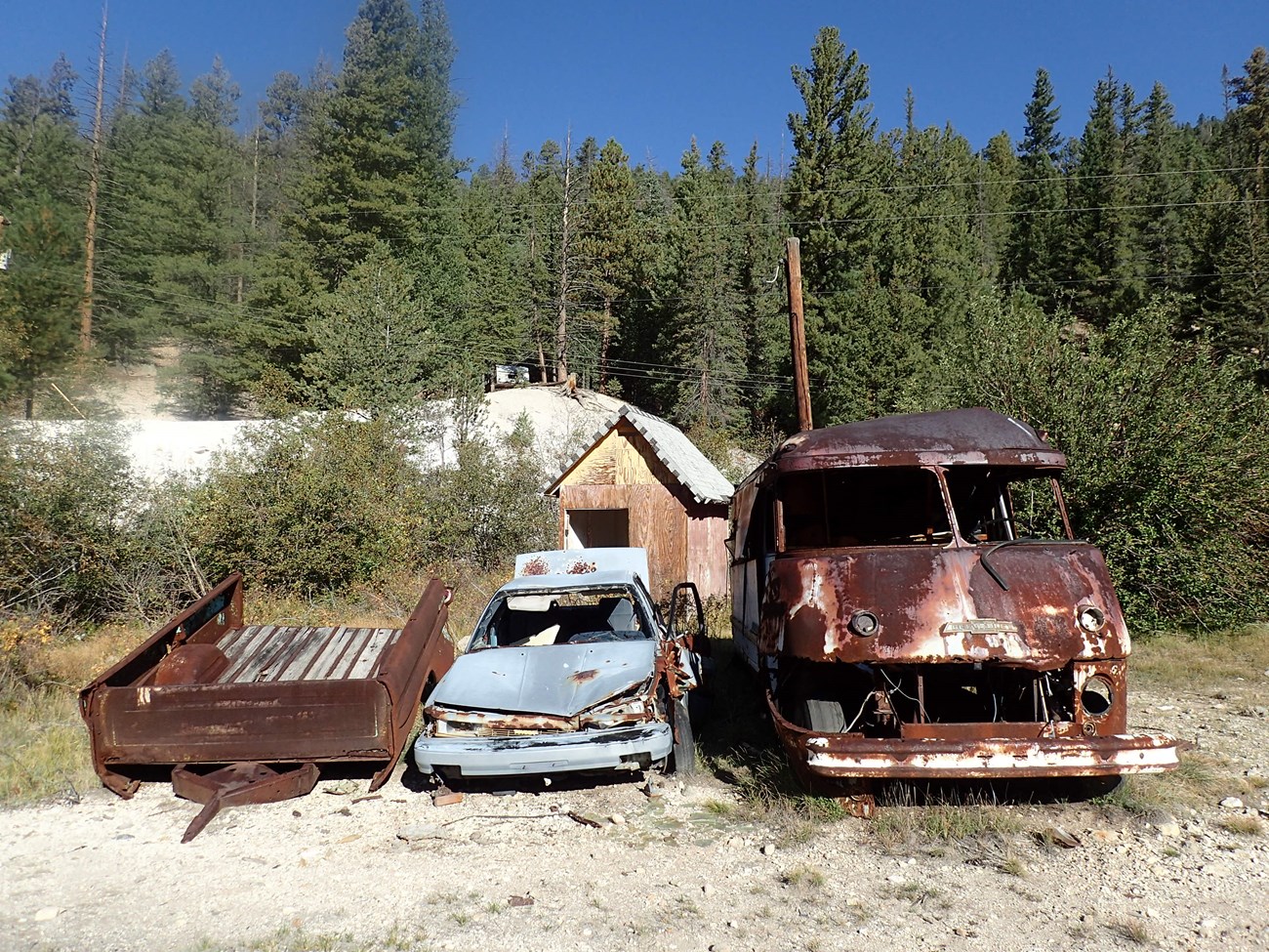 Abandoned mine site Rusted cars with forest in the background