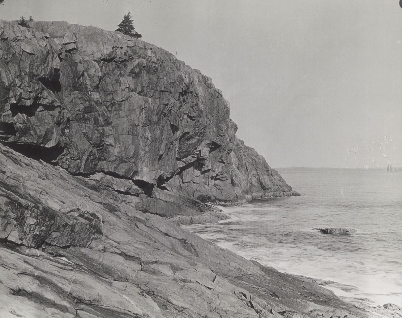 Black and white photo of a cliff and ocean