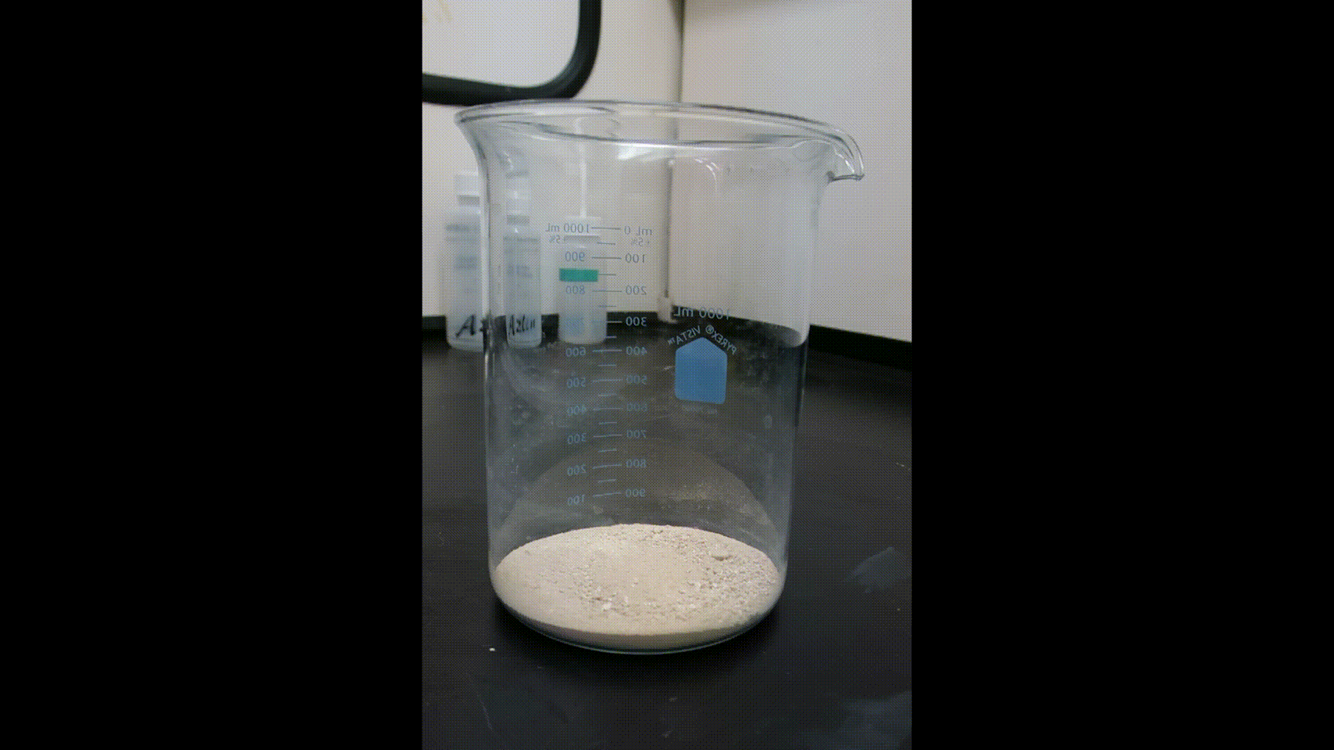 Animation of acid added to crushed mortar in a glass beaker and subsequent foaming.