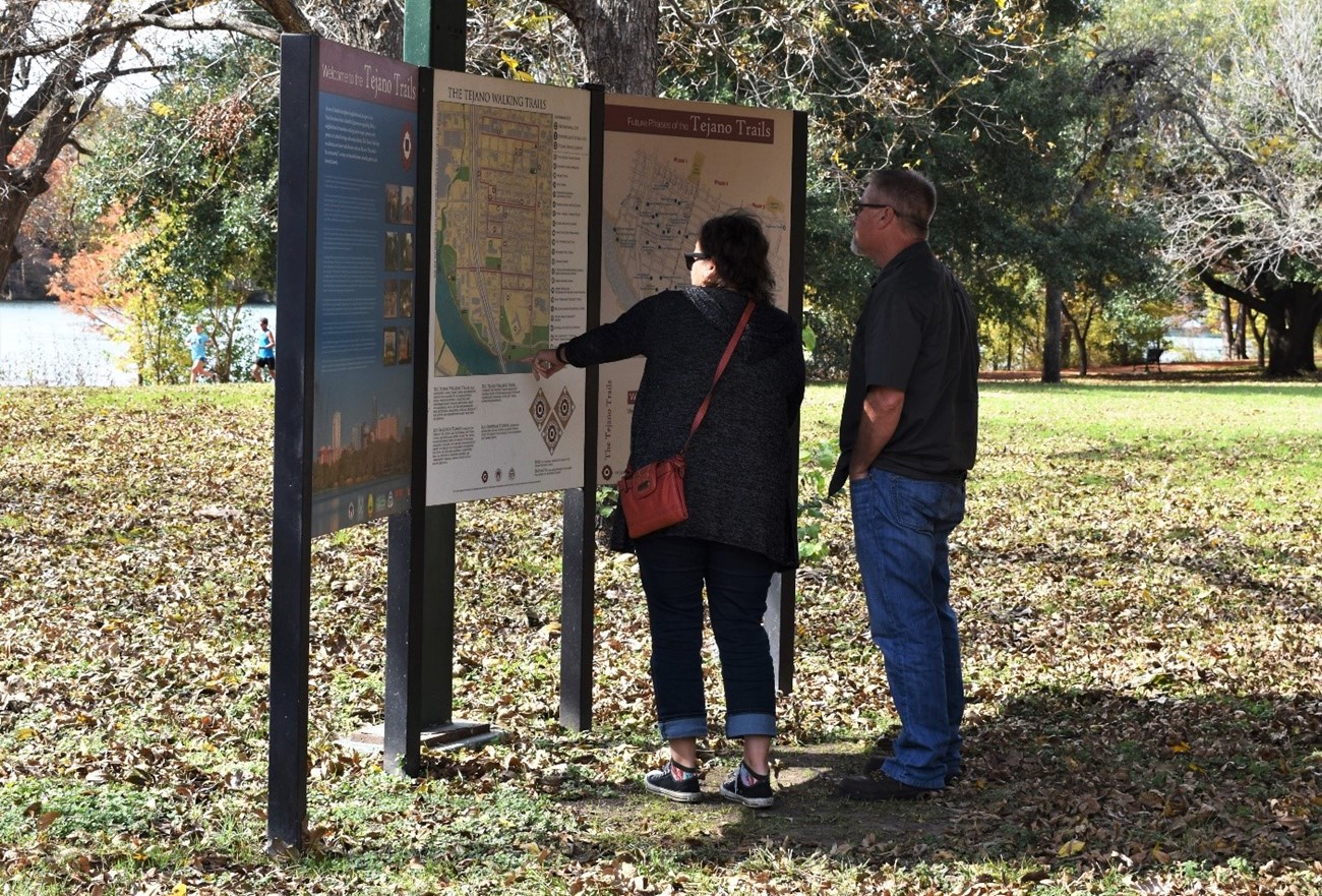 Visitors learn about the Tejano Trails at the trailhead kiosk. National Park Service photo. Visitors learn about the Tejano Trails at the trailhead kiosk. National Park Service photo.