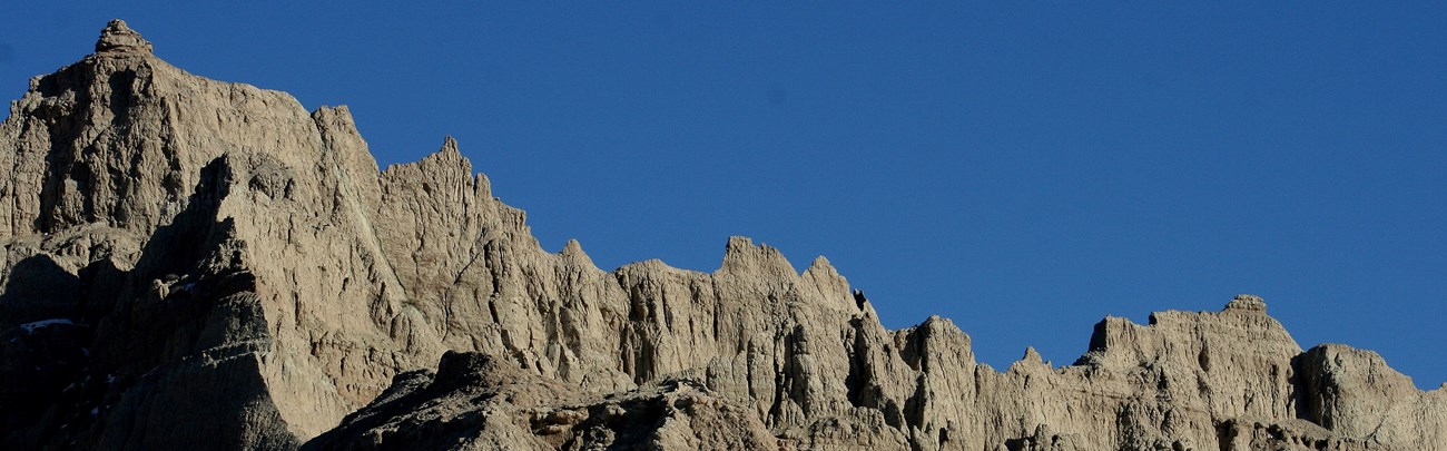 jagged buff badlands peaks poke into a clear blue sky