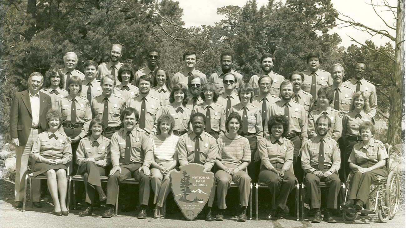 Shirley Beccue at NPS ranger skills NPS employees pose for a group photo. Most wear NPS uniforms but a few are in street clothes. Shirley Beccue in her wheelchair is in the front row.