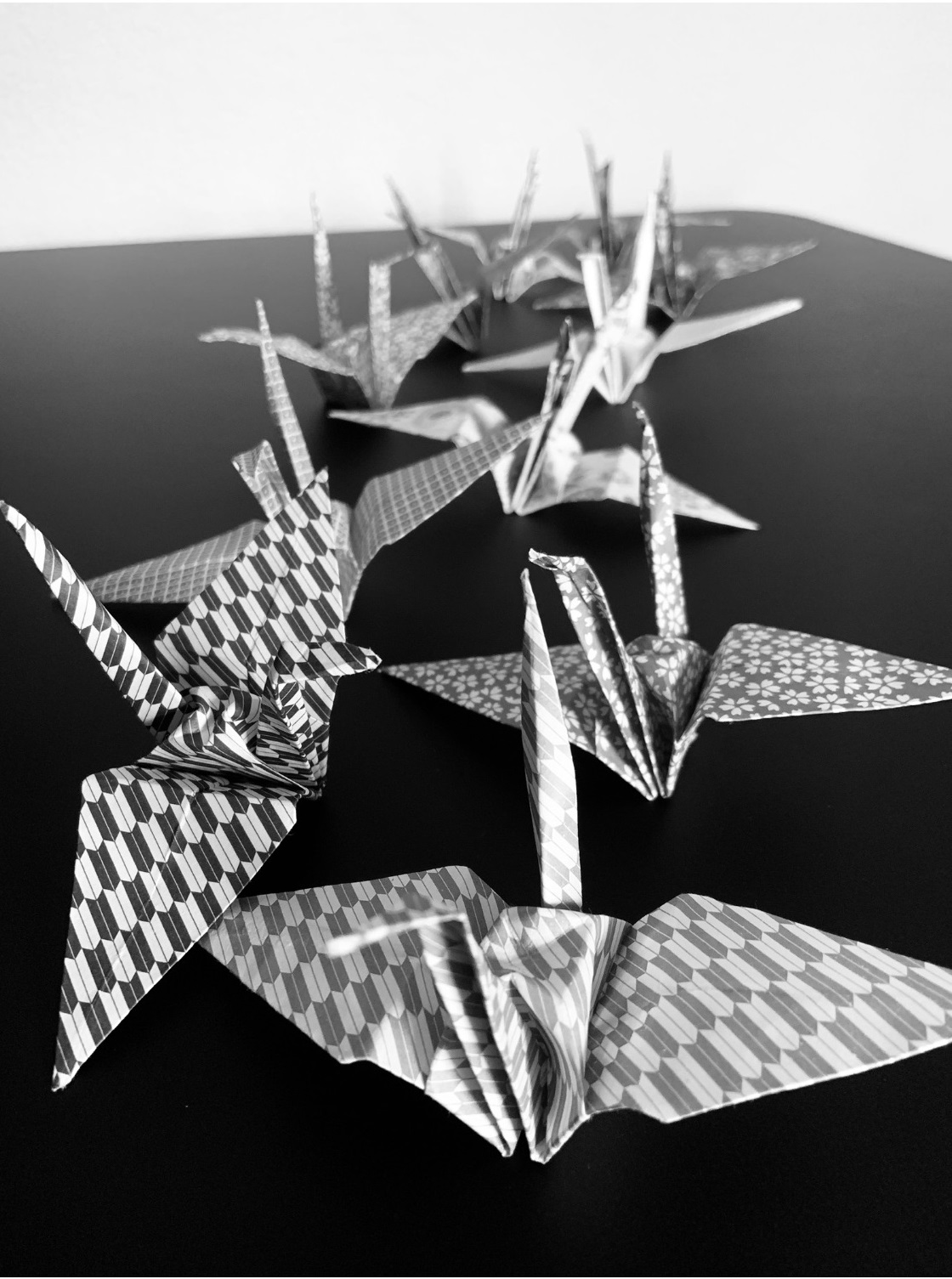 Black and white photo of origami cranes on table