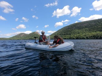 scientists conducting pond research two individuals conduct scientific research in a boat on a pond