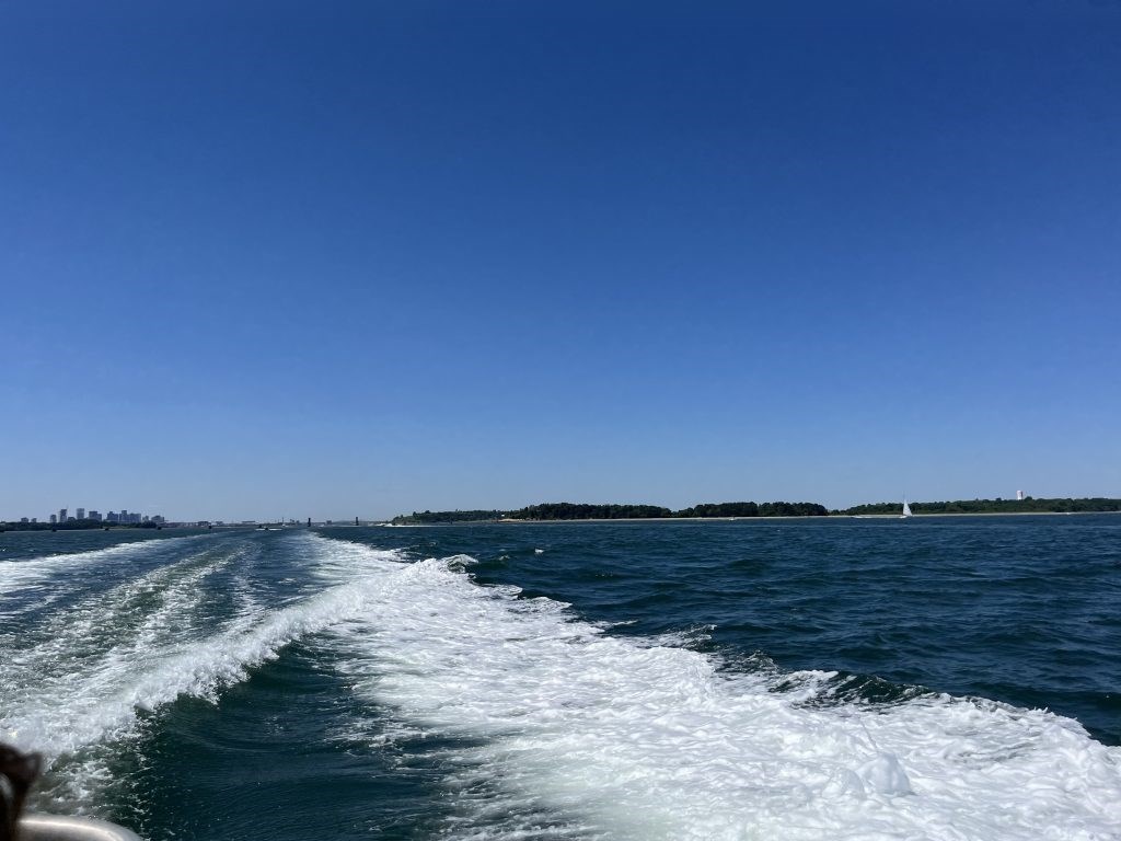 boat_wake-1024x768 a deep blue Boston Harbor with white foam from the wake of a boat.