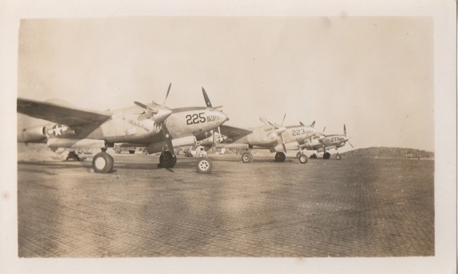 Three propeller planes on the tarmac.