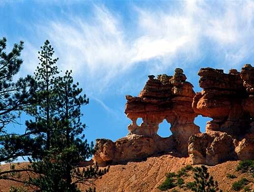 Rock formations against a blue sky with wispy white clounds