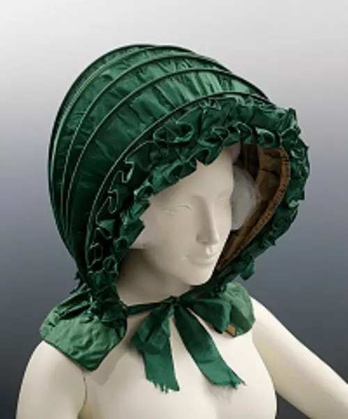 Calash A green calash headpiece worn by a mannequin