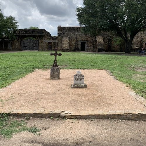 two tombs in front of church, one with a cross