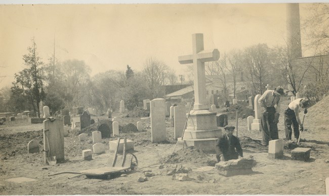 cemoverhaul men working, with shovels, in a cemetery, many gravestones visible