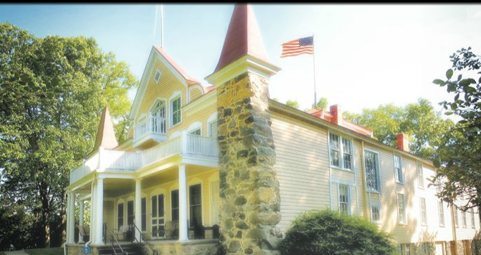 clarabartonnhs house is yellow with a white porch on the top part of the home