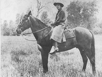 Clare Marie Hodges on a horse in a meadow.